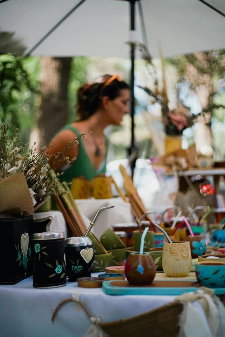 Colorful handmade cups and decorations displayed at an outdoor festival market.